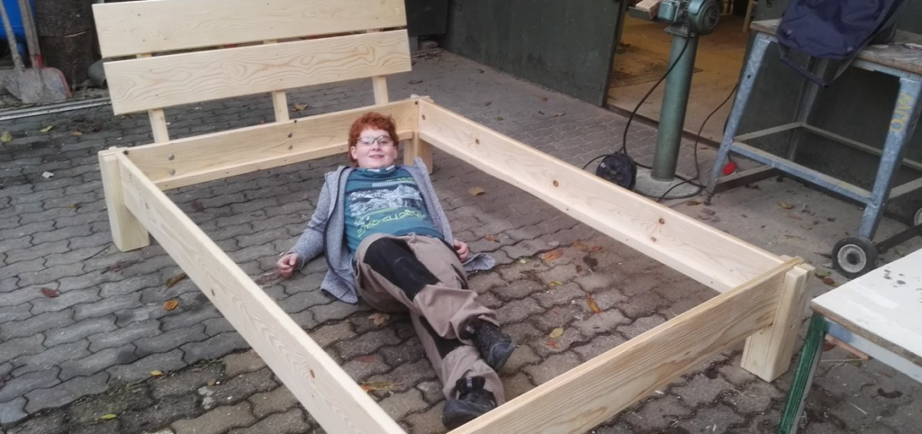 Junge präsentiert sein selbstgebautes Bett